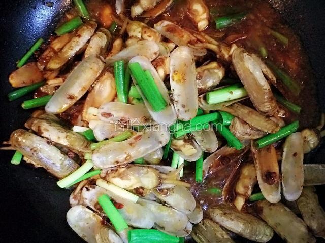 蛏子全部张开快熟时放入小葱炒。