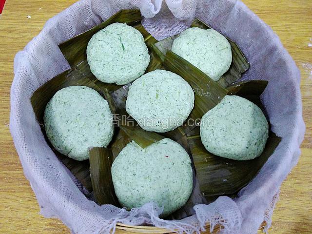 蒸笼内铺上浸湿的纱布，放入青团生坯，每个青团间要间隔一些空间。