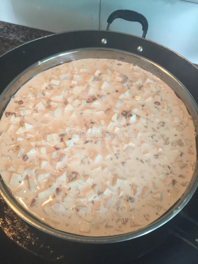 大锅里热开水，把圆盘里面擦点油，这样芋头糕就不会粘盘，把准备好芋头米浆倒入平整一下。盖上锅盖蒸60分钟。