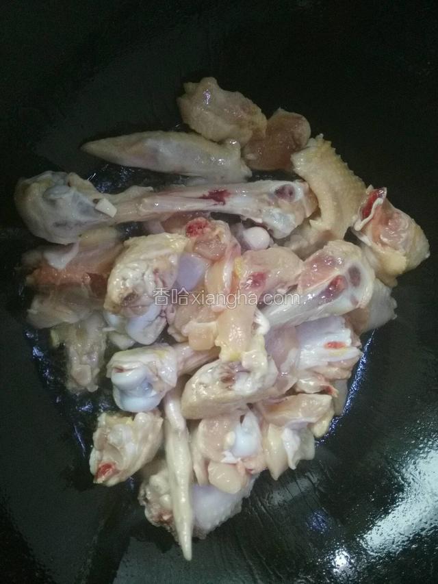 热锅下油，下鸡肉块翻炒至变色。