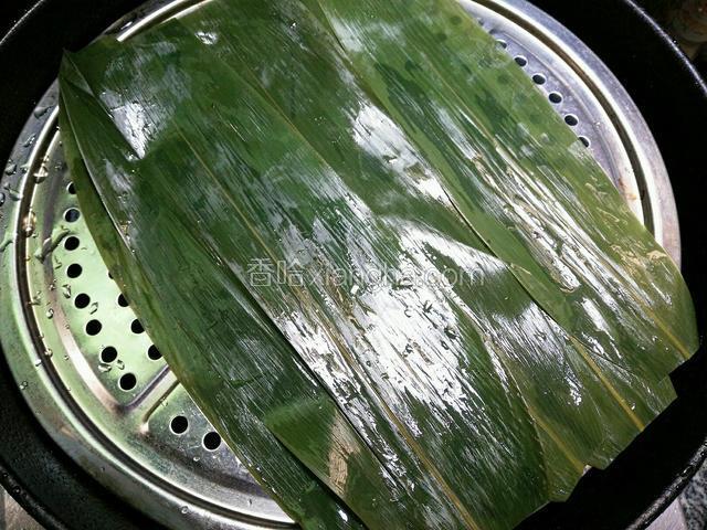 锅里加水，放上蒸屉，洗好的棕叶剪去两头平铺上