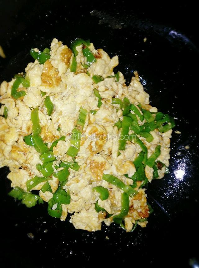 鸡蛋快熟的时候，放入青椒。翻几下，滴几滴香油。