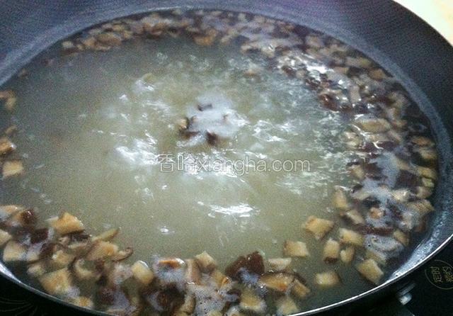 锅中水烧开，放入干贝、香菇和大米一起煮。