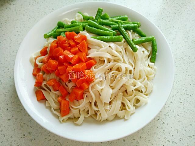 胡萝卜、豇豆铺在面条上。