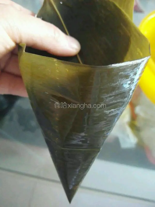 拿出一至两片粽叶围成锥形