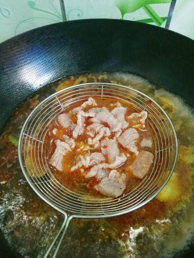 肉片放入漏勺浸入锅中煮至肉打卷捞出放在白菜上