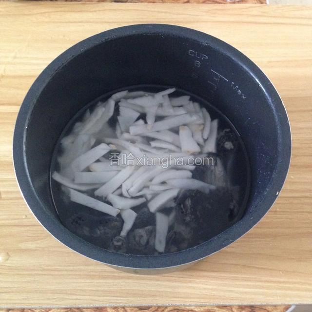 椰子壳破开，用刀割出最里面的那层白肉，切丝放入乌鸡中。