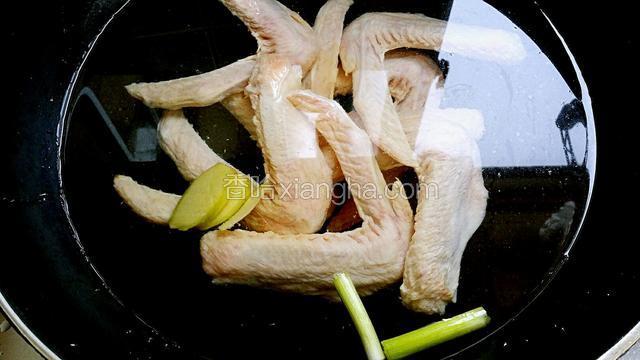 鸭翅冷水入锅，加少许料酒，姜片去腥，大火烧开后煮3分钟左右，捞出洗净（没有去干净的杂毛可焯水后去除，这样比较容易）