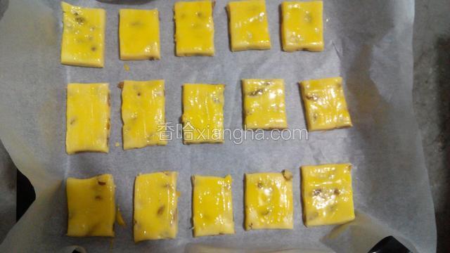 把小面片放入铺了油纸的烤盘里，表面刷蛋黄液
