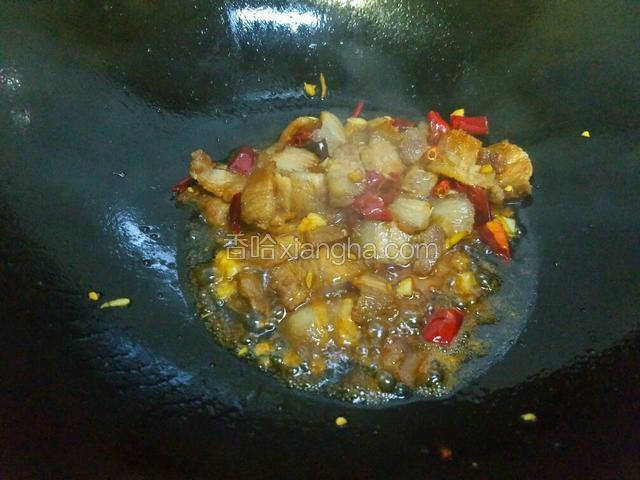 炒出香味后，往锅里倒入老抽将肉上色，