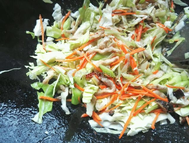 再倒入包菜、胡萝卜丝翻炒调入适量盐、味精、料酒、生抽、老抽、醋大火翻炒几下再加入适量清水烧开
