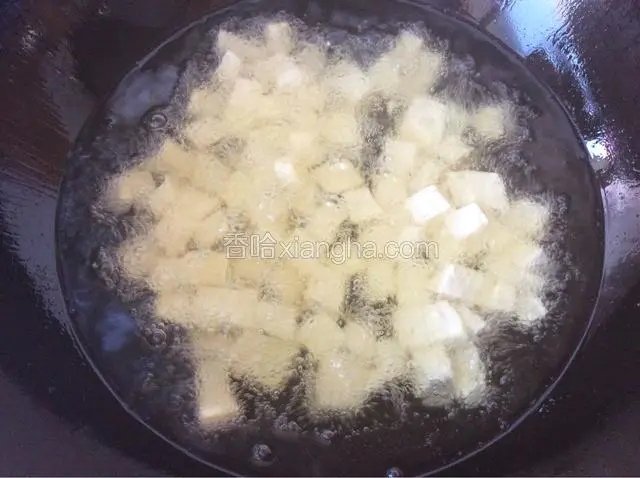 锅中多倒些油烧热放入豆腐，将豆腐炸至金黄色。