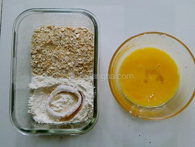 腌制后的鱿鱼圈首先放入生粉中，表面均匀的粘满生粉