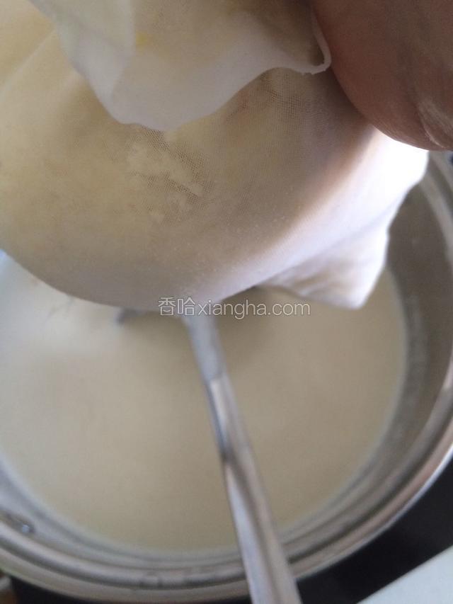 豆浆打好了，用纱布袋开始过滤豆渣。如果浮沫太多可以用勺子撇掉浮沫。