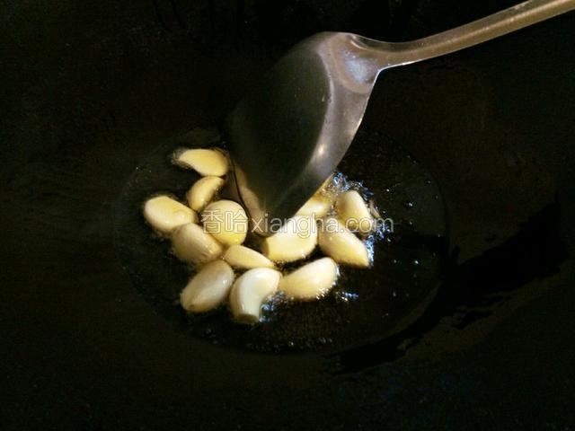 热锅倒油烧热，下大蒜瓣小火煸炒出香味。