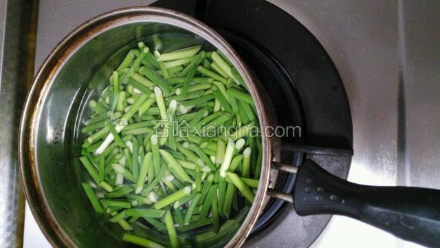 锅中倒水，水开始冒小泡时下蒜苔，汆烫半分钟