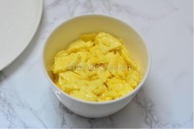 将煎好的鸡蛋在锅中用铲子切块倒起备用。