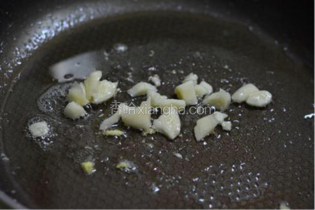 锅中倒入适量油爆香蒜碎。