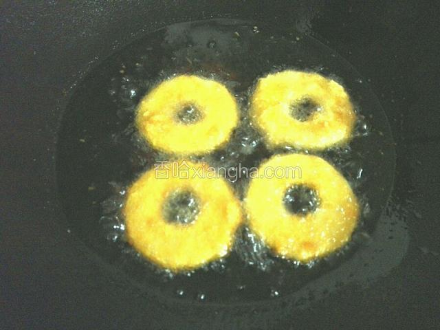油锅烧至油温七成热下入苹果圈中小火炸制表面金黄即可