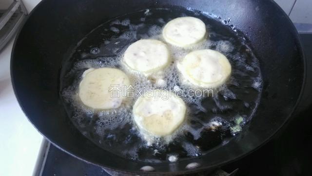 油锅放油大火烧热转中火放入逐个做好的茄盒放入炸