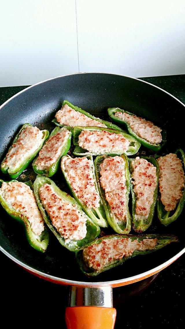 煎至肉成金黄色后翻面再煎，煎至青椒变软、起皮即可。