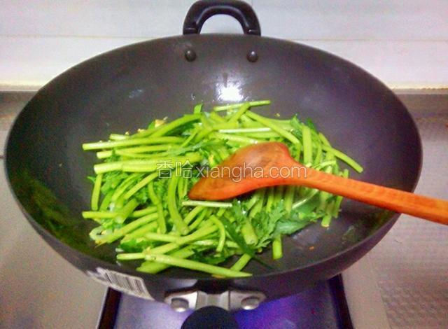 然后倒入茼蒿根茎翻炒至变软。