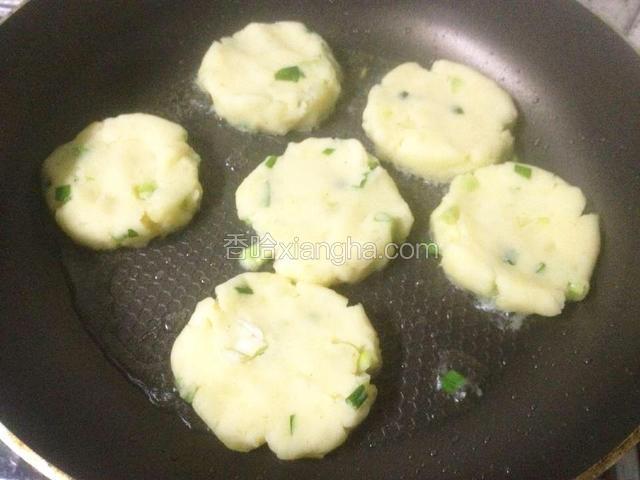 平底锅放适量油烧热,下土豆饼小火烙成金黄色.
