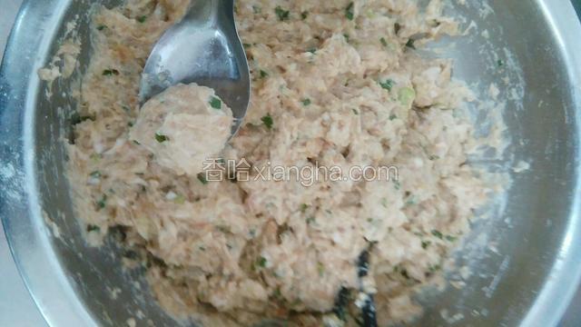 用勺子挖出一个个肉丸放入锅内。