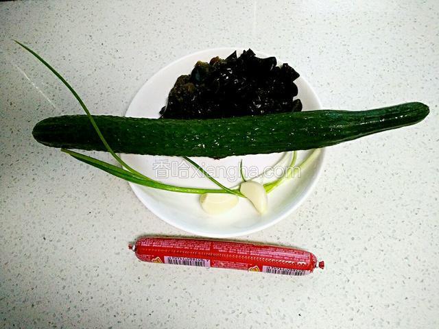 木耳提前泡发洗净，撕成小块，黄瓜、葱、蒜洗净、火腿肠。