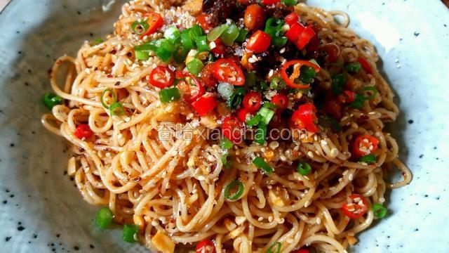 装盘后再摆上花生醉、自制辣酱，再撒上些白芝麻、白糖、葱花和小米椒碎。