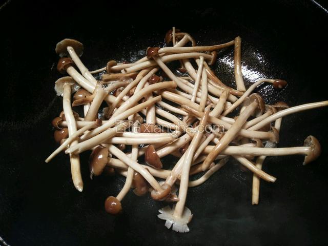再热锅下少许油，下茶树菇翻炒片刻