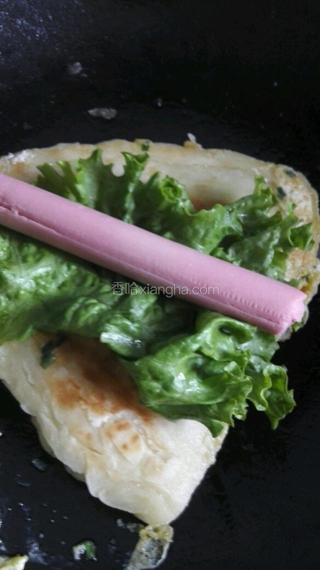 烙熟出锅，沫上甜面酱放入生菜火腿，