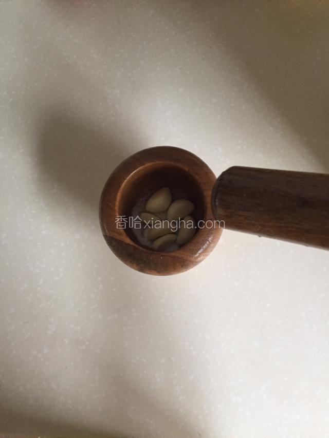 大蒜加入盐后捣碎。