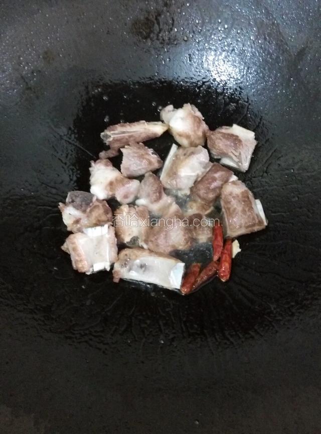 爆炒至表面微焦，加入干小米椒炒出香味。