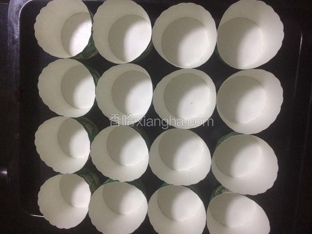 将小号纸杯均匀的摆放在烤盘上