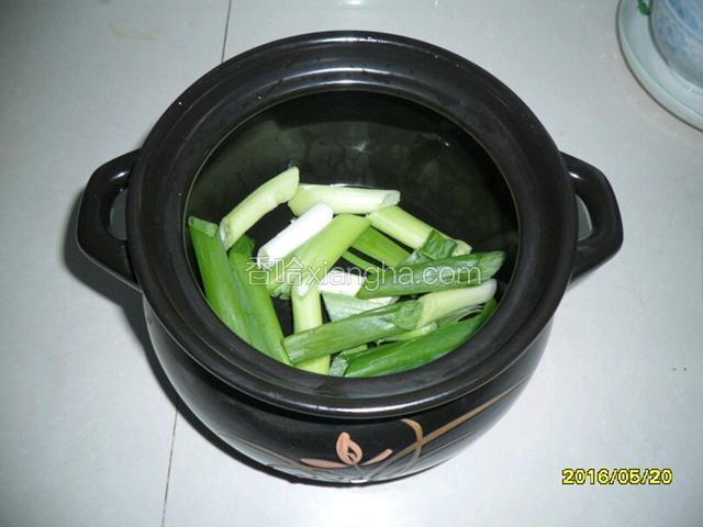砂锅内铺入葱段，姜片