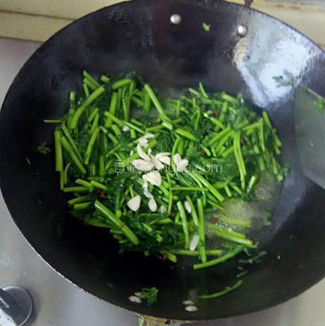 放入蒜末，盐，继续翻炒，待茼蒿断生后即可出锅。