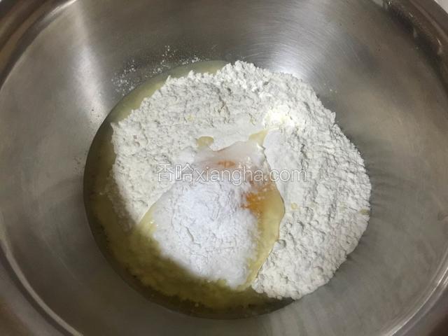 面粉中打入一个鸡蛋，加入适量无铝泡打粉和盐。