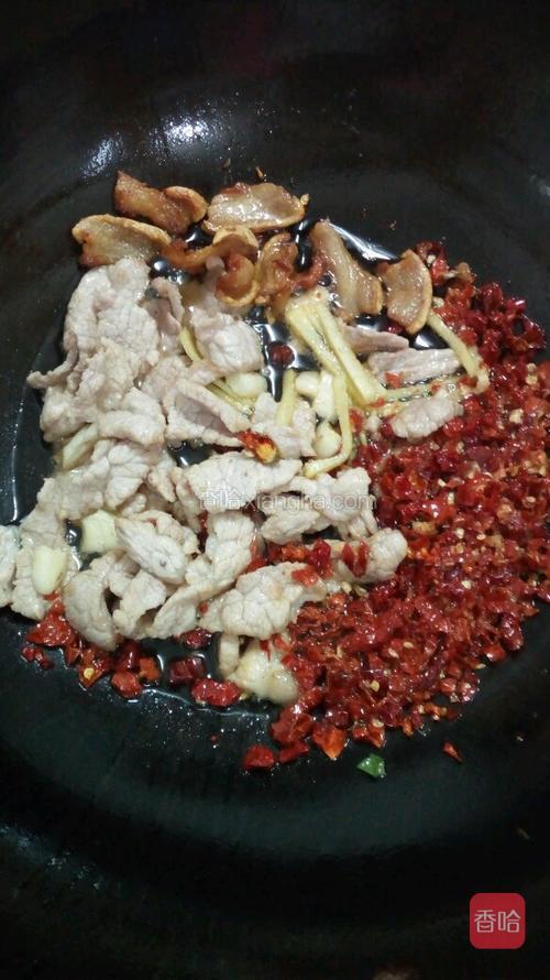 当瘦肉炒至变色，马上倒入干红辣椒、生姜、大蒜。