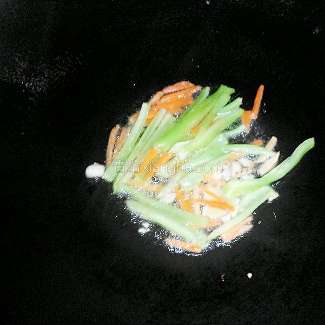然后放入青椒和胡萝卜,煸炒柔软