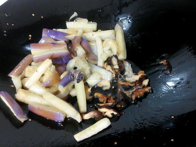 再下香菇在油里炒香，再和茄子炒均匀