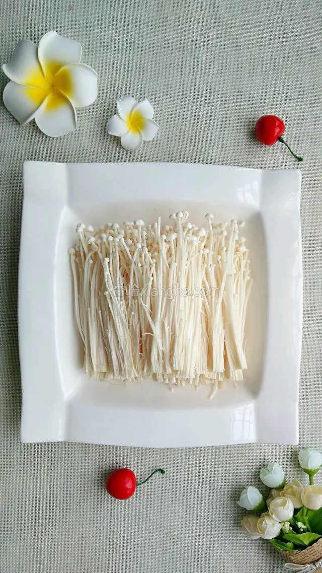 金针菇洗净后切去根部，用手撕成小条条摆进盘子里。