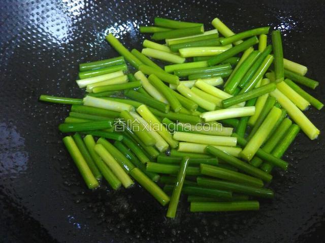 锅里再放些油烧热，放入蒜苗炒匀