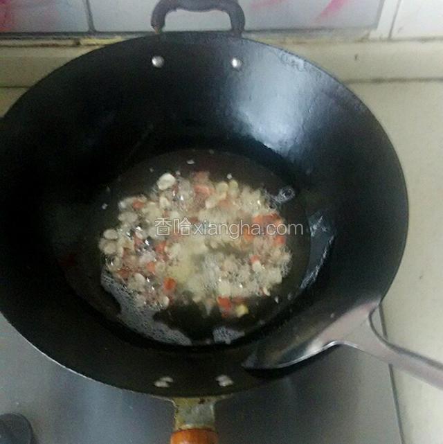 凉锅倒入花生油，放入花生碎。小火炸至花生碎颜色微黄，捞出花生碎，放入辣椒碗中。