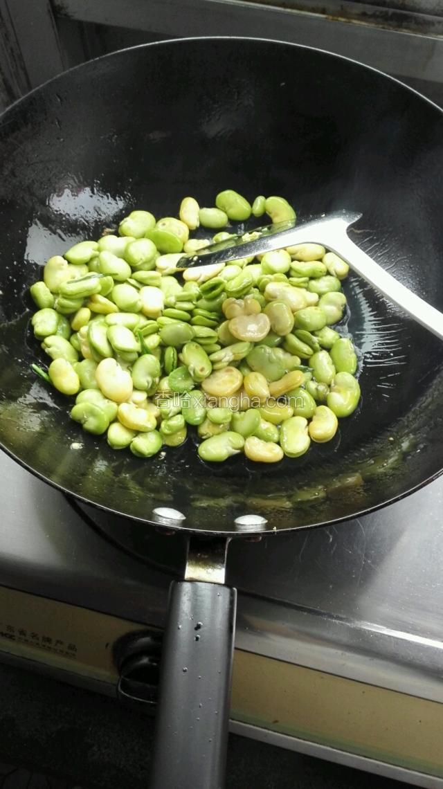 再往锅内倒少许油，7成热后倒入蚕豆米