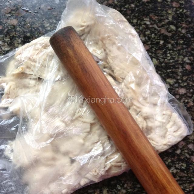 煮熟的鸡胸肉捞出晾凉，放入保鲜袋，用擀面杖敲松。