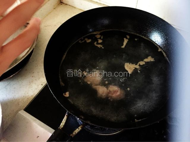 左手捏起肉团，在虎口位置捏出肉馅，右手揪出一个圆形，下入锅中。