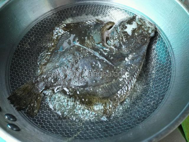 坐锅加油热后下多宝鱼煎至两面变色，加葱姜蒜、八角、白酒、米醋、老抽。