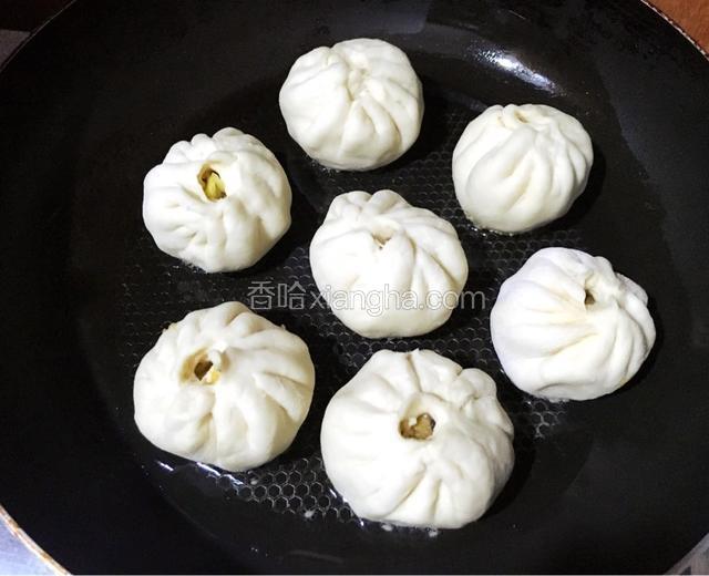热锅放入油烧热，放入包子，煎制底部芝麻微黄，倒入一小碗清水