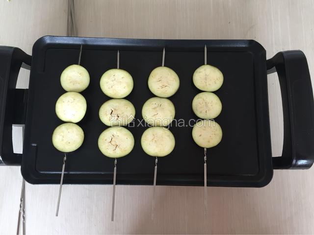 电烤盘预热，茄子擦油放入电烤盘